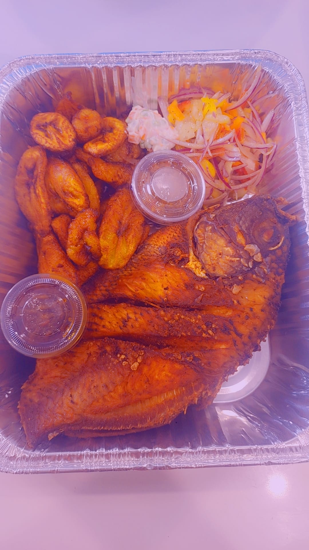 Whole fried fish with fried plantains and salad