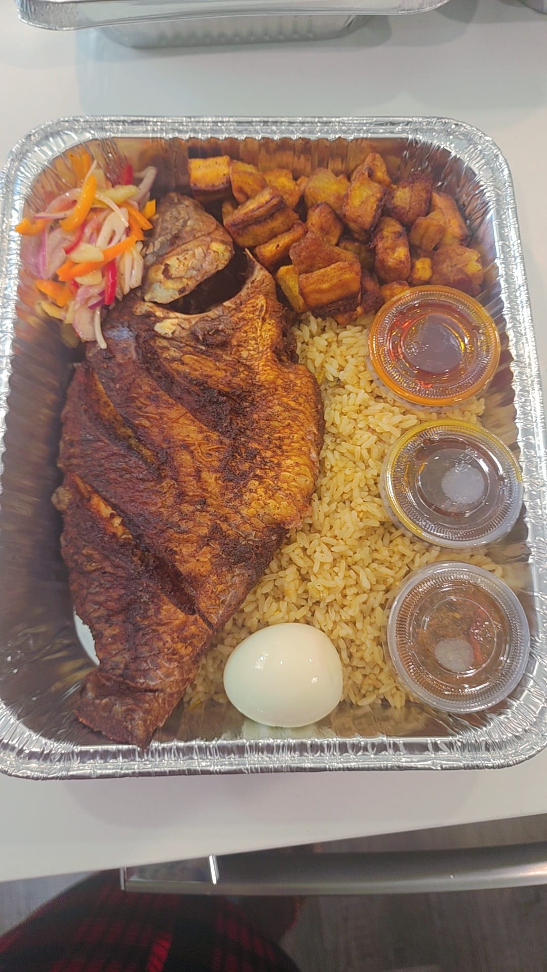 Waakye style plate with fish, plantains, egg and sauces